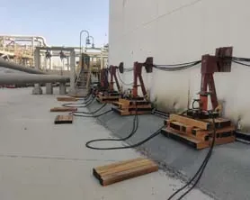 Self-climbing hydraulic jacks lifting a storage tank for repair