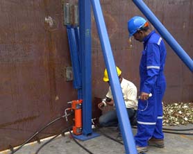 Tank jacking equipment being installed in a tank ready to be lifted in order to erect shell plates for the next shell course; Bygging hydraulic jacking system; Bygging Tank welding system