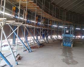 Hydraulic jacks with lifting hooks to erect steel tanks; no welding of lifting cleats to tank shell required 